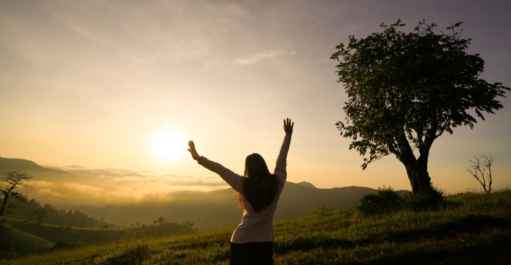 woman open arms at sunrise