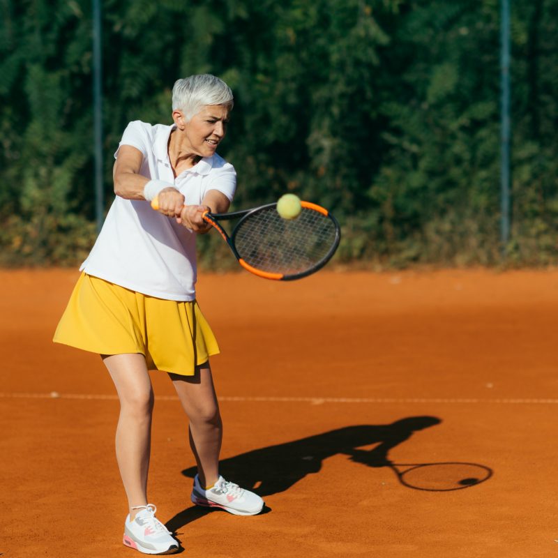 Positive Active Mature Woman Having a Tennis Lesson